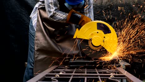 trabajador industrial que utiliza un molinillo eléctrico para cortar.