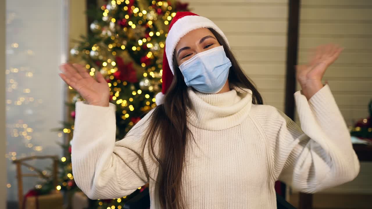 크리스마스 때 마스크와 산타 모자를 입은 여자