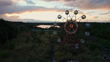 Drone-Aéreo-Primer-Plano-Noria-Parque-De-Diversiones-Abandonado-En-Japón-Cielo-Al-Atardecer-Isla-De-Ocio-Kejonuma,-Paisaje-Natural-Rural-Cubierto-En-Asia,-Raro-Lugar-De-Viaje