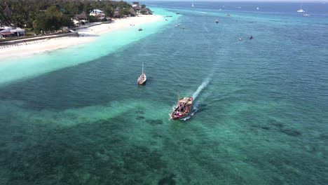 aerial backwards tracking shot of typical zanzibar boat sailing on sunny day