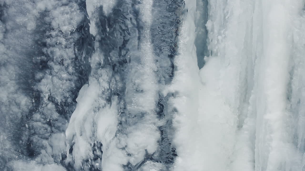 Ice background. Ice surface. Icy waterfall. Water flow under ice. Close Up