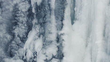 Eishintergrund.-Eisfläche.-Eisiger-Wasserfall.-Wasserfluss-Unter-Eis.-Nahaufnahme