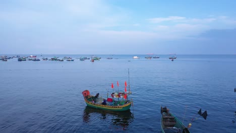 aerial fly over a small vietnamese fishing boat returns to shore after a night at sea