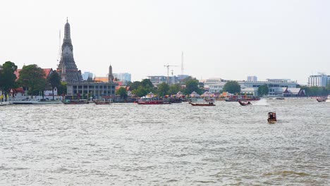 boat travels past wat arun temple in bangkok