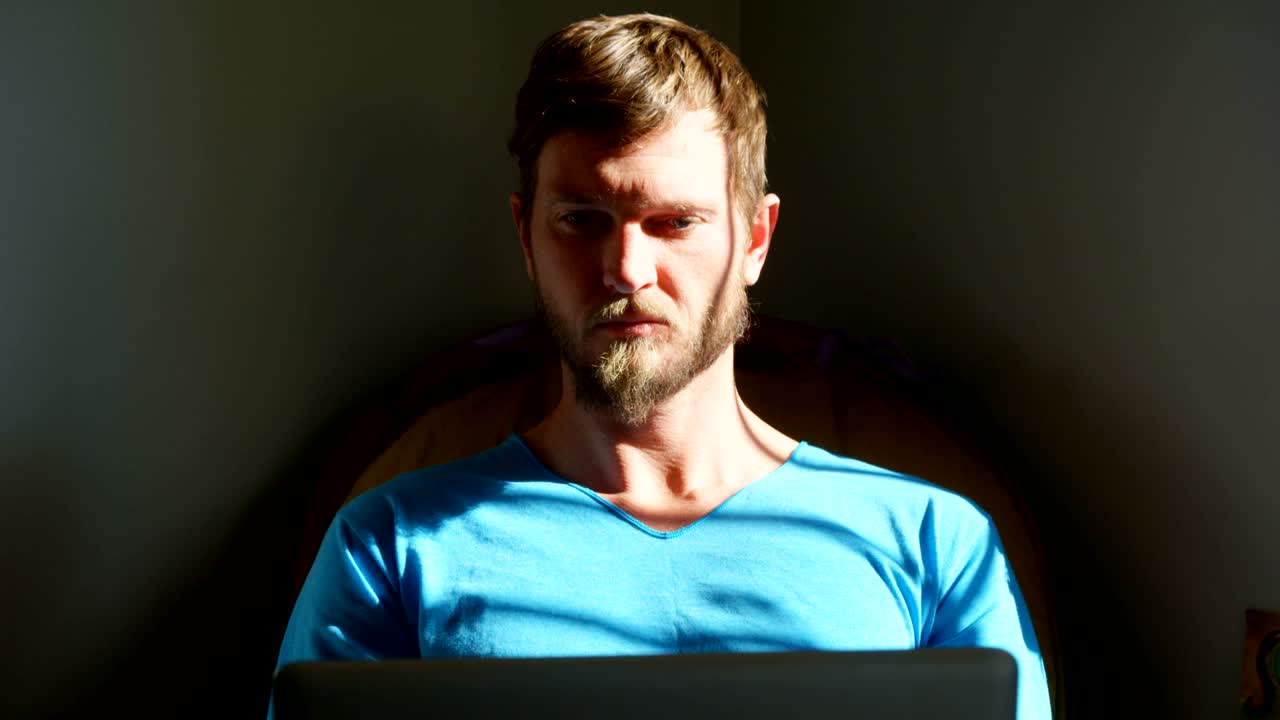 Man using laptop at home 4k