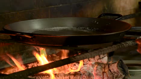 authentische und traditionelle spanische paella-küche mit feurigem brennholz in barraca, valencia