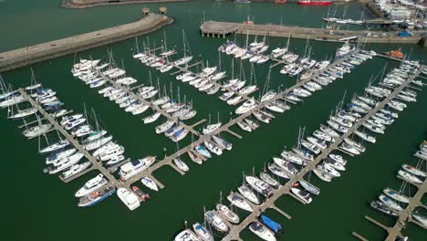 overhead aerial shot, pushing forwards and overhead, revealing boats on a marina on a sunny day