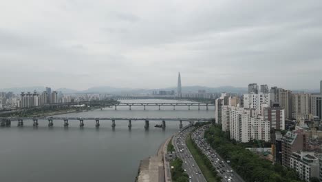 aerial shot flying over han river and seoul city with lotte world tower, south korea