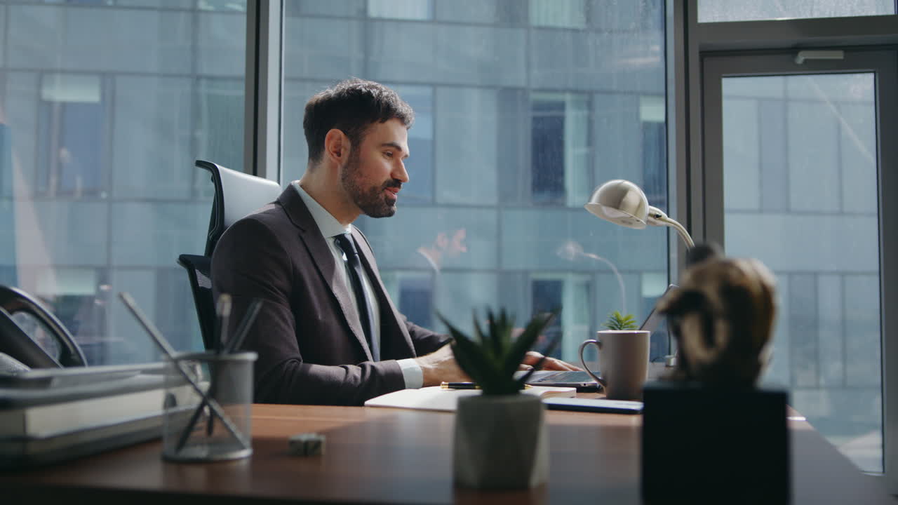 manager sorridente saluto videoconferenza seduto ufficio. uomo riunione online