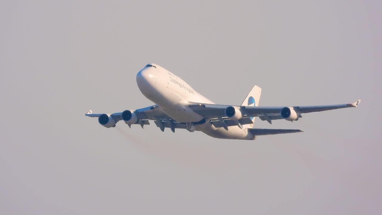White Boeing 747 cargo jet taking off against a clear blue sky, demonstrating the power of air travel and global commerce with a challenge accepted sign on it, Toronto, Canada