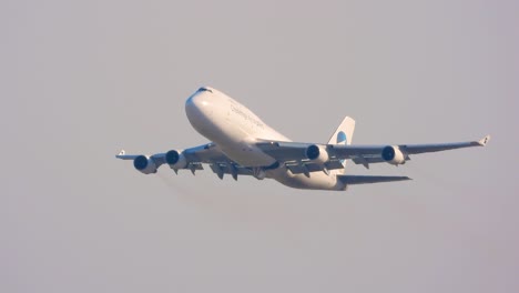 white boeing 747 cargo jet taking off against a clear blue sky, demonstrating the power of air travel and global commerce with a challenge accepted sign on it, toronto, canada