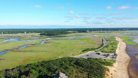 imágenes aéreas de drones de cape cod de marismas y casas frente a la playa durante la marea baja con gente y hierba verde alta