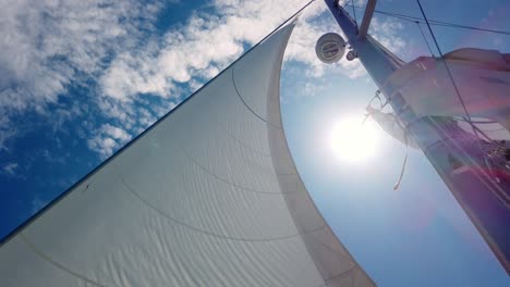 slow motion shot of giant white sail while sailing in windy and sunny summer day