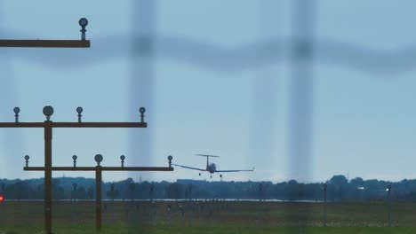 small white training airplane with propeller engines landing at airport in sunny summer day, medium shot from a distance