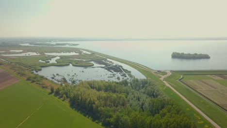 aerial drone shot of flying forward and tilting down on the beautiful road goes to the coastline in the netherlands