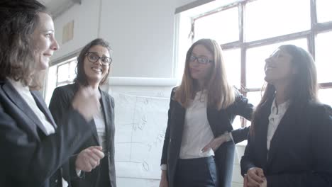 mujer de negocios comprobando el reloj de pulsera y mirando a sus colegas