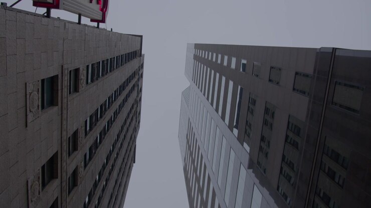 Olhando para cima para dois edifícios altos em um dia de neblina na cidade