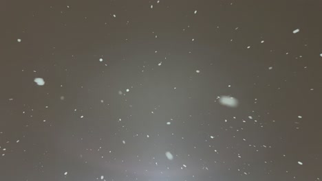A Close Up of Snow Falling on a Gray Surface. A detailed view of water particles, resembling astronomical objects, falling as precipitation on a dark and moist gray surface