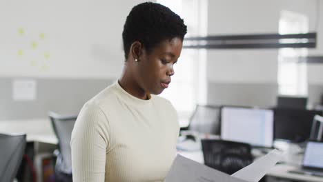 Fokussierte-Afroamerikanische-Geschäftsfrau,-Die-Dokumente-Im-Büro-überprüft