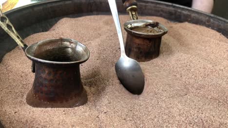 traditionally cooking coffee in hot sand in a coffeepot known as "cezve" in turkish, turkey.