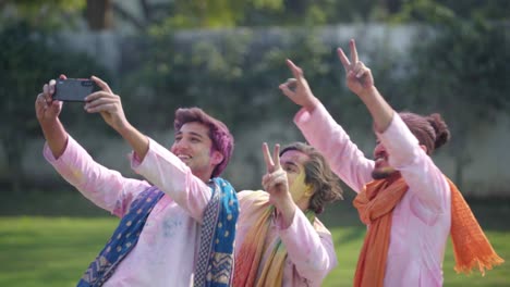 indian men clicking selfies at holi festival in traditional wear