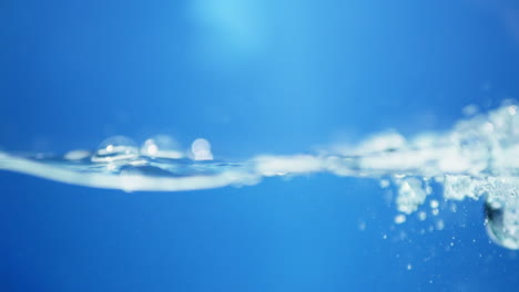 Vista-Macro-De-Dinámica-De-Fluidos-De-Gotas-De-Agua-Dulce-En-Movimiento-Sinfonía-De-La-Naturaleza-Efecto-De-Ondulación-Del-Agua-En-Cámara-Lenta-En-Tono-Azul