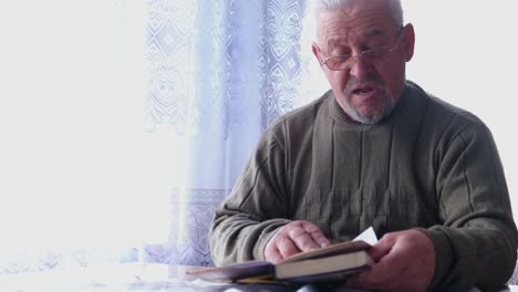 elderly man looking through a photo album