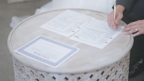 groom signing legal marriage license papers