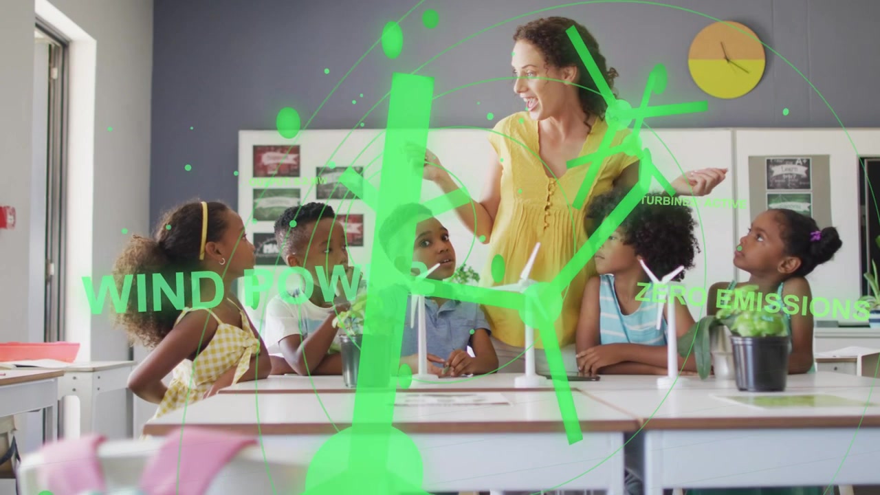 Teacher gesturing, teaching with animated overlay linking turbines and plants to WIND POWER