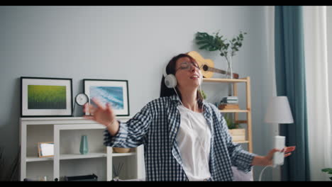 woman dancing and listening to music at home