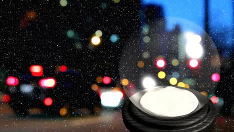 Animation-of-snow-falling-over-christmas-snow-globe-with-out-of-focus-city-lights