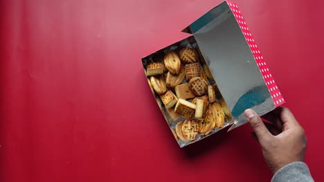 las manos de una persona alcanzando una caja de galletas