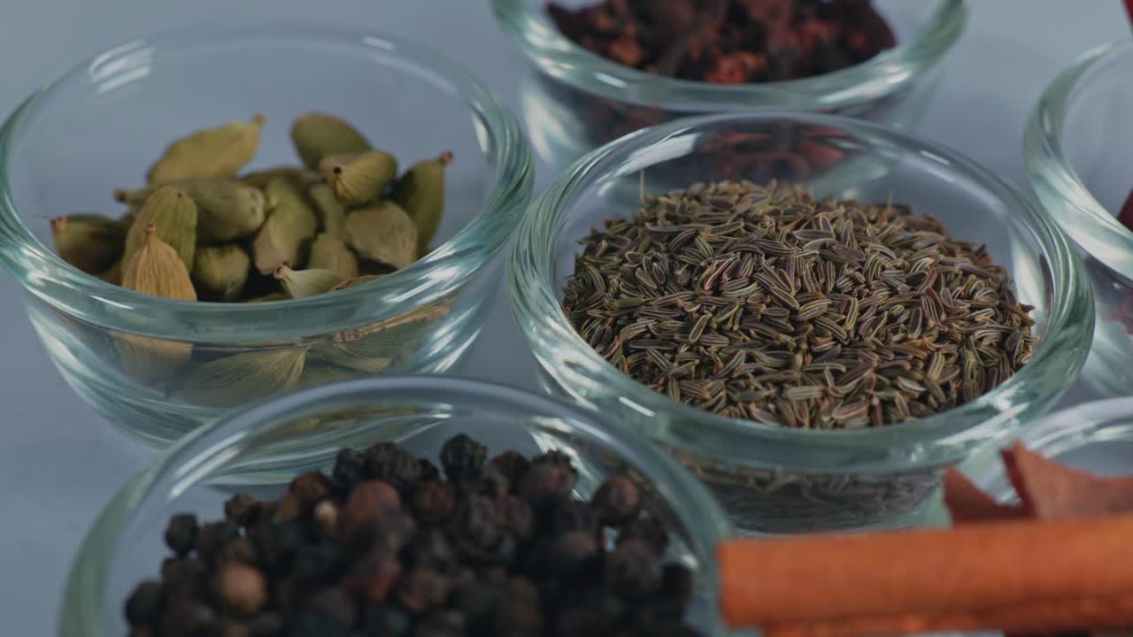 different types of indian whole spices or garam masala in small glass bowl, 4k, parallax shot.