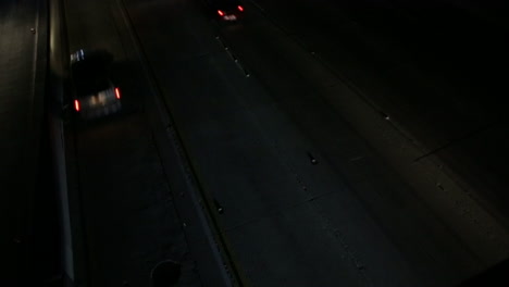 stationary down view form overpass shot of cars on the freeway at night