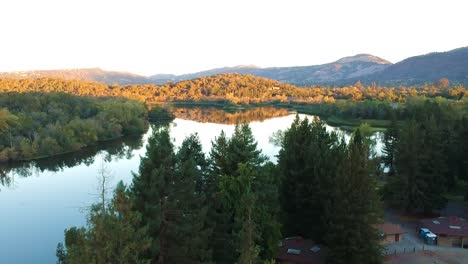 vuelo aéreo sobre el lago y los árboles antes del amanecer