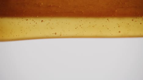 close up of honey dripping off a wooden ledge