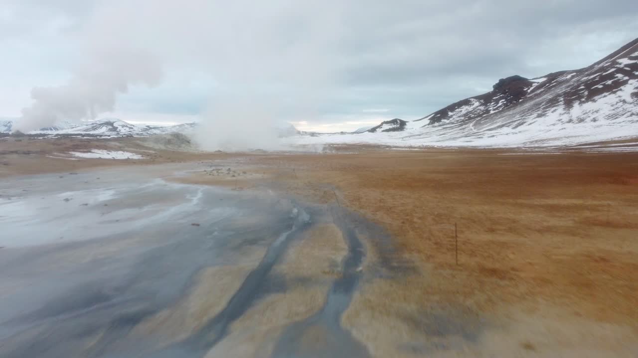 Aerial shot of the geothermal landform Hverir, with bubbling pools of mud and steaming fumaroles emitting sulfuric gas