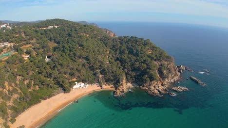 Ruhige-Drohnenaufnahmen-Enthüllen-Die-Pracht-Von-Lloret-De-Mar,-Wobei-Cala-Canyelles-Den-Reiz-Der-Malerischen-Küste-Der-Costa-Brava-Noch-Verstärkt