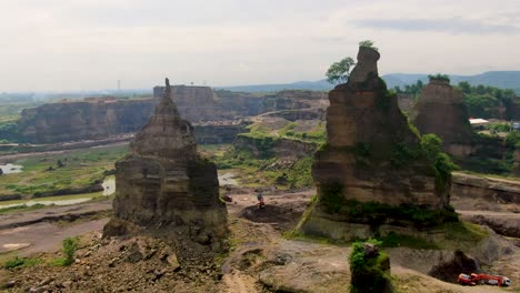 passing two rock columns to reveal aerial panorama of brown canyon quarry, java