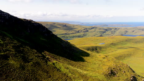 drone shot of stac pollaidh in the northwest highlands of scotland, revealing water behind the mountain