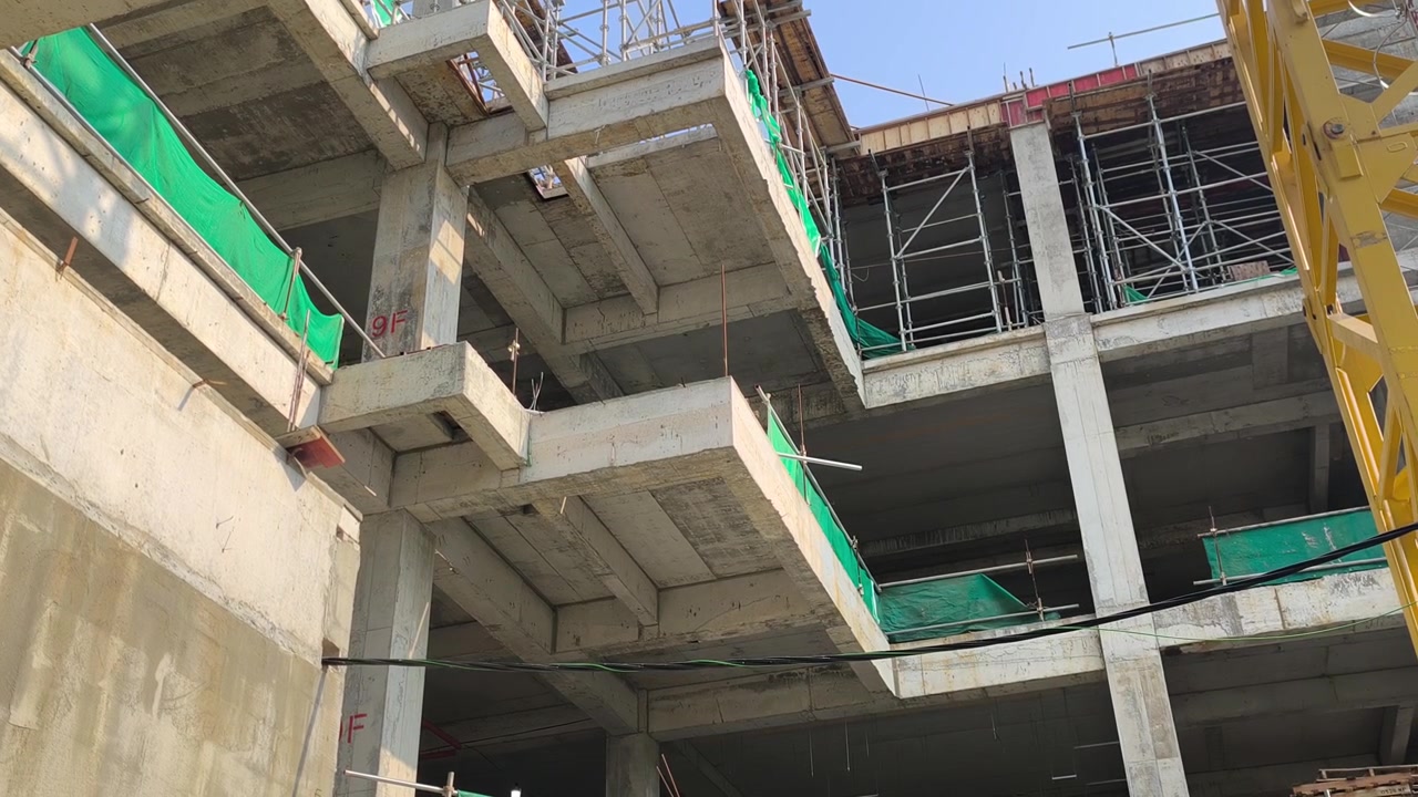 Toma en ángulo bajo de una viga en voladizo de hormigón armado que soporta una losa de piso. Vista estructural dentro de una obra de construcción moderna activa