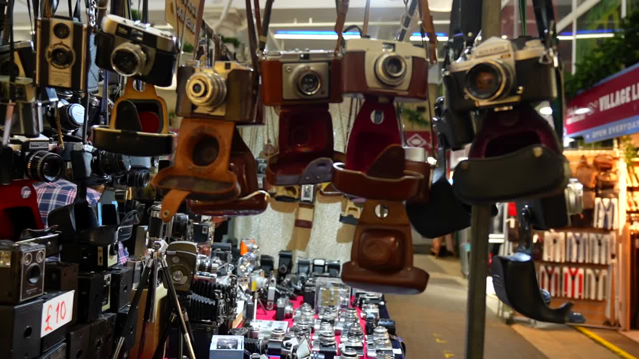 Vintage cameras displayed for sale at a London street market stand, rack focus shot