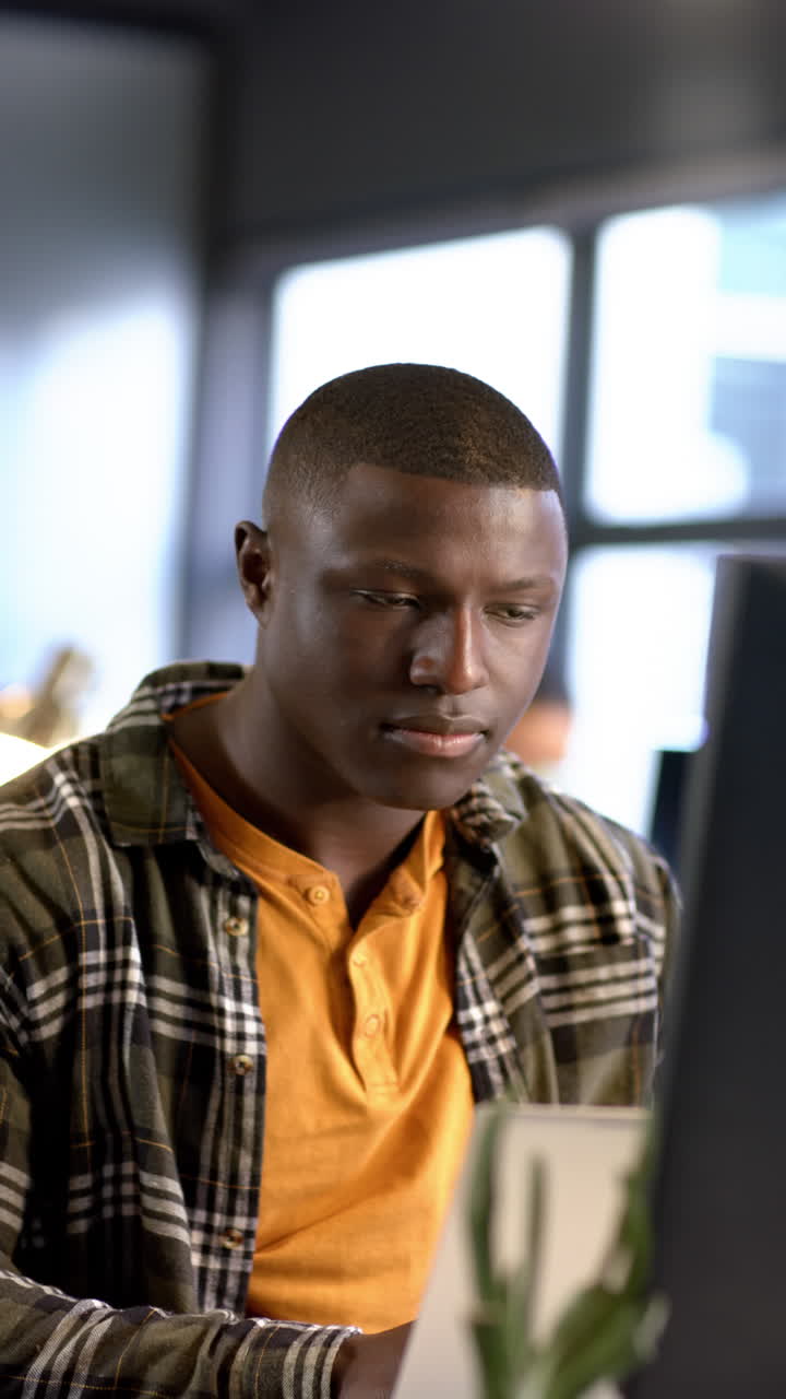 Vertical video of african american businessman in office, slow motion, copy space