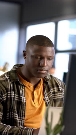 vertical video of african american businessman in office, slow motion, copy space