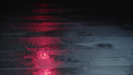 Red-traffic-light-reflecting-on-wet-asphalt