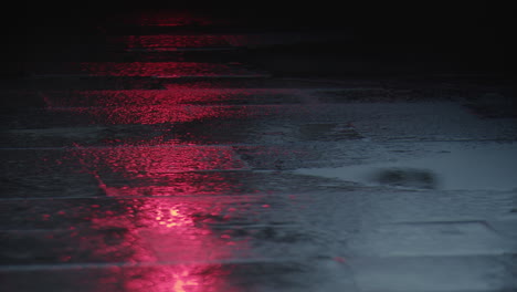 luz de tráfico roja que se refleja en el asfalto mojado