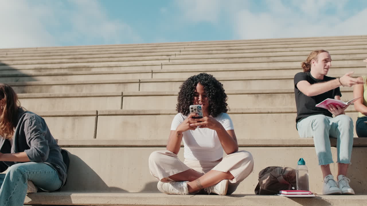 Close up of an african-american girl using smartphone outdoors, zooming out