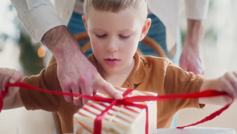 close-up of young boy wrapping christmas present