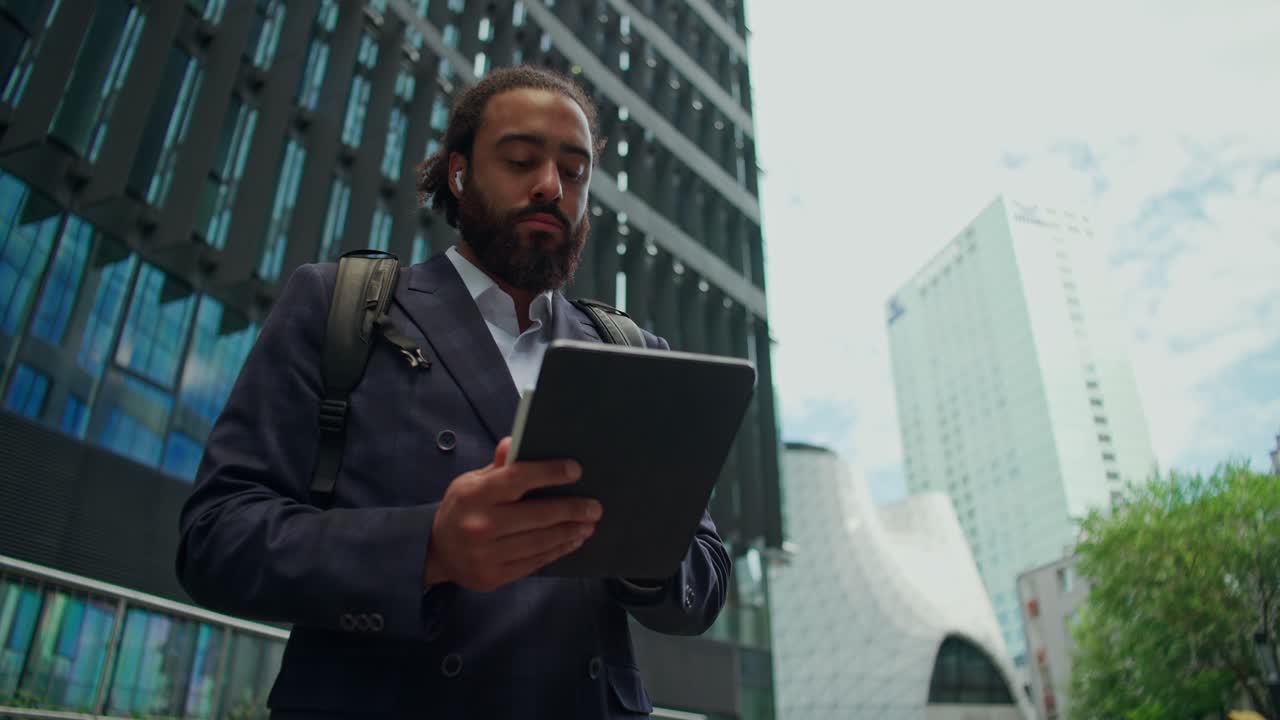 Uomo d'affari che usa il tablet in città