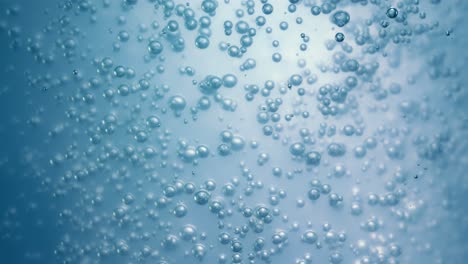 muchas burbujas de agua en agua azul de cerca, onda de agua abstracta con burbujas en cámara lenta.